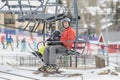 Father & Toddler Son Safely On a Ski Lift at a Colorado Mountain Resort with the Ski Area in the Background