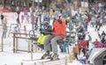 Father & Toddler Son On a Ski Lift at a Colorado Mountain Resort with Crowds of People in the Background. Waving & Smiling.