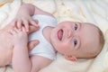 Father is touching laughing baby lying down