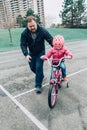 Father training helping girl daughter to ride bicycle. Royalty Free Stock Photo