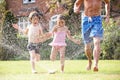 Father And Two Children Running Through Garden Royalty Free Stock Photo