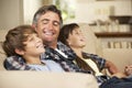 Father And Two Children Sitting On Sofa At Home Watching TV Together Royalty Free Stock Photo