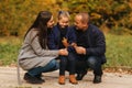 Father and two daughters in the forest. Autumn weather and colorful background. Happy family. Two sister show their love Royalty Free Stock Photo