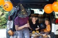 Father two kids celebrating Halloween in car trunk. Autumn holiday Royalty Free Stock Photo