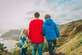 Father and two kids travel hiking looking at nature