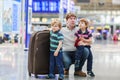 Father and two little sibling boys at the airport Royalty Free Stock Photo