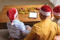 Father and two sons having a video call on digital tablet with copy space at home during christmas Royalty Free Stock Photo