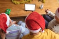 Father and two sons having a video call on digital tablet with copy space at home during christmas Royalty Free Stock Photo