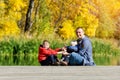 Father and two sons play on the dock. Autumn, sunny. Side view Royalty Free Stock Photo