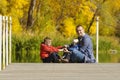 Father and two sons play on the pier. Autumn, sunny. Side view Royalty Free Stock Photo