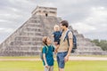 Father and two sons tourists observing the old pyramid and temple of the castle of the Mayan architecture known as