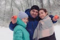 Father and two teenage daughters on winter walk in forest. Snowfall in the foreground, frost  trees. Happy family weekend. Royalty Free Stock Photo