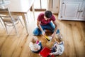 Father and two toddlers with brush and dustpan.