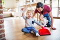 Father and two toddlers with brush and dustpan.