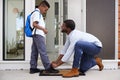 Father Tying Sons Shoelaces As He Leaves For School