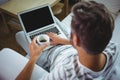 Father using laptop while having coffee in living room Royalty Free Stock Photo