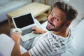 Father using laptop while having coffee in living room Royalty Free Stock Photo