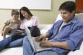 Father Using Laptop, mother and son Looking at DVD