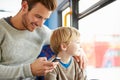 Father Using Mobile Phone On Bus Journey With Son Royalty Free Stock Photo