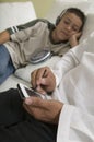 Father Using PDA on sofa with Son Listening to Music close up of hands of father Royalty Free Stock Photo