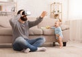 Father using Virtual reality headset, sitting with baby