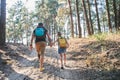 Father walking with daughter on path in forest