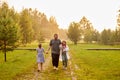 Father walking with daughters in countryside in sunset Royalty Free Stock Photo
