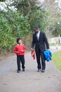 Father Walking Son To School Along Path