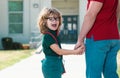 Father walking son to school. Parent and pupil of primary school schoolboy with backpack. Portrait of amazed nerd school