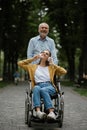 Father walks with disabled daughter in wheelchair