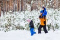 Father walks with his young children in the woods in winter