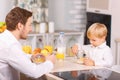 Father watches his son eating cornflakes Royalty Free Stock Photo