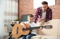 Father watching his son playing guitar Royalty Free Stock Photo