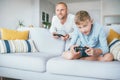 Father watching his son playing TV video game using the gamepad Royalty Free Stock Photo