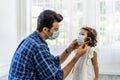 Father is wearing the face mask for little daughter, both are wearing face masks for confidence in their health.