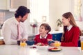 Father Wearing Suit Having Breakfast With Children In School Uniform Before Work Royalty Free Stock Photo