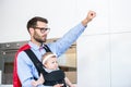 Father wearing superhero costume carrying daughter