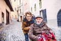 Senior father in wheelchair and young son on a walk. Royalty Free Stock Photo