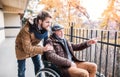 Senior father in wheelchair and young son on a walk. Royalty Free Stock Photo