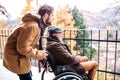 Senior father in wheelchair and young son on a walk. Royalty Free Stock Photo