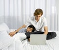 Father work at home with son. A boy napping on his father`s lap while the father using laptop computer to work in the bedroom. Royalty Free Stock Photo