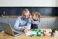 Father Working from home on laptop during quarantine. Little child girl make noise and distracts father from work Royalty Free Stock Photo