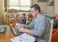 Father working in home office and son playing