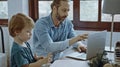 Father working from home office using laptop sit at table with cute little son playing nearly to disturb Royalty Free Stock Photo