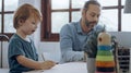 Father working from home office using laptop sit at table with cute little son playing nearly to disturb Royalty Free Stock Photo