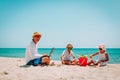 Father working on laptop while kids play at beach Royalty Free Stock Photo