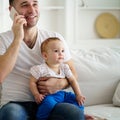 Father working, talking on phone and babysitting Royalty Free Stock Photo