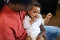 Father& x27;s Care. Cute African American Baby Relaxing In Dad& x27;s Arms Royalty Free Stock Photo