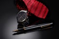 Father& x27;s Day or business concept image. Elegant man& x27;s watch, fountain pen and red tie on black gradient background.