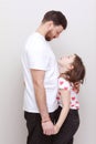 father& x27;s day. side view affectionate little child daughter holding hands with smiling bearded father. Happy small kid